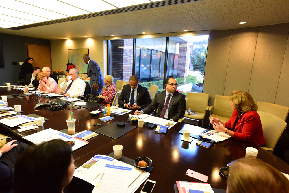 A large group of colleagues sitting together at a meeting table